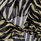 Close-up of the RONNY KOBO Kyle Zebra Print Maxi Top, featuring sheer fabric with striking black and white zebra stripes, arranged in gentle folds and layers for a textured and abstract look.