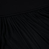 Close-up of the RONNY KOBO Meyer Draped Hemline Dress in black, featuring gathered pleats for a textured, wavy look. A smooth upper section contrasts with draped folds at the hem, creating a minimalist dress aesthetic.