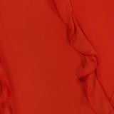 Close-up of the Milena Draping Maxi Dress by RONNY KOBO, showcasing red fabric with wavy, ruffled edges that run diagonally across the image, creating a textured and layered look evocative of fluid draping.