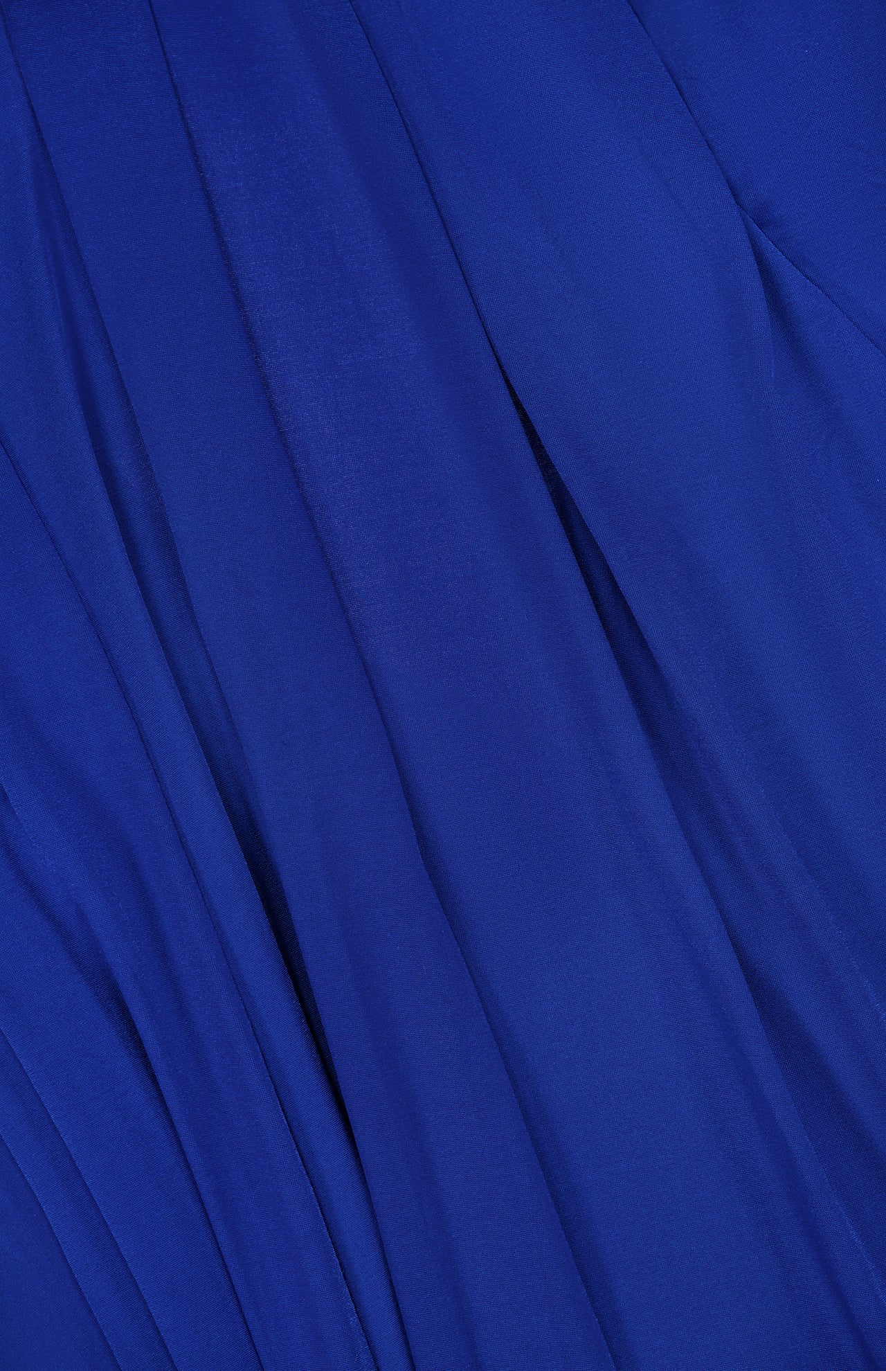 A close-up of smooth blue fabric with soft folds and gentle draping, inspired by the Rhodes Draped Maxi Dress from RONNY KOBO, highlighting movement and textured elegance.