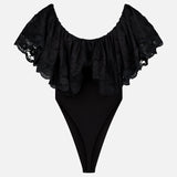 The Rosette Lace Detail Bodysuit by RONNY KOBO is a black off-the-shoulder top with delicate lace in a wide, ruffled neckline overlay. This fitted, high-cut going-out piece stands out on a plain white background.