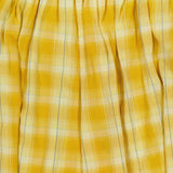 The Ryker Plaid Balloon Pant by RONNY KOBO features yellow and white plaid fabric with gathered, pleated folds at the top, evoking a relaxed pull-on silhouette.