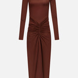 The Scorpio Ruched Waist Dress by RONNY KOBO is a chocolate brown column dress with long sleeves, a mock turtleneck, and a fitted bodice. Ruched waist detailing creates a draped effect on its mid-length skirt.