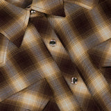 Close-up of the Tatie Plaid Western Shirt by RONNY KOBO, featuring a brown and beige plaid pattern, silver snap buttons, and two chest pockets. Perfect as a fall fashion piece, this western blouse includes a shirt tag in the corner that reads RONNY KOBO.