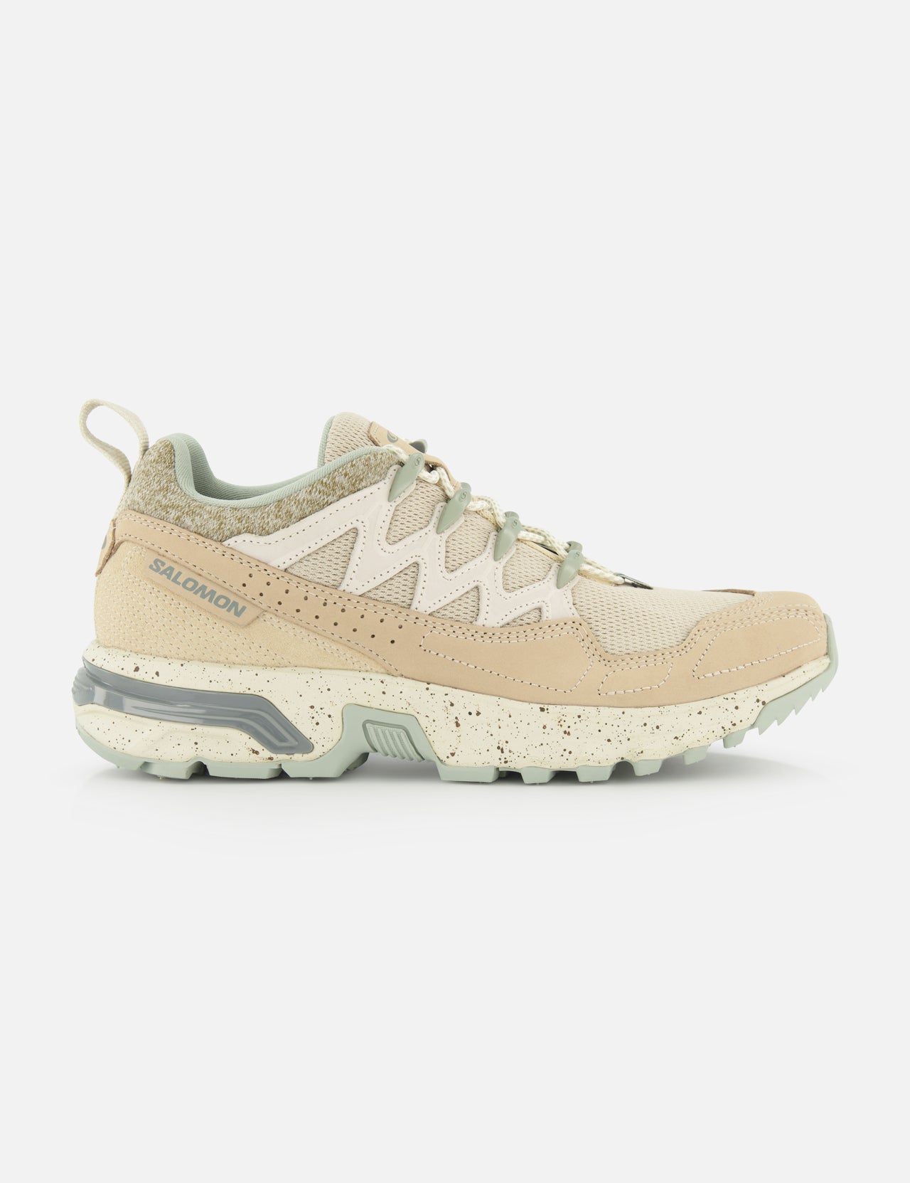 The SALOMON ACS + Cozy Sneaker in beige and light green features mesh details and a chunky, speckled sole. Shown in side profile against a white background.