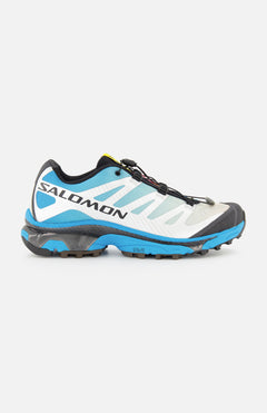 The SALOMON XT-4 OG Sneaker, shown from the side on a white background, is a trail running shoe in blue, white, and black featuring an Agile Chassis Skeleton and quick-lace system for enhanced stability and agility.