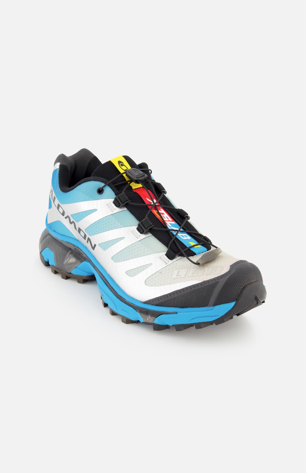 The SALOMON XT-4 OG Sneaker is displayed at an angle on a plain white background, showcasing its blue, white, and black colorway, signature quick-lace system, rugged outsole tread, EnergyCell midsole cushioning, and branded detailing on the side—making it an excellent option for those looking for high-performance trail running shoes engineered for outdoor adventures.
