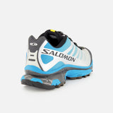 The SALOMON XT-4 OG Sneaker in blue, white, and black—showcasing the brand’s innovative Agile Chassis Skeleton—is displayed from the back against a plain white background, emphasizing its performance-oriented trail running design.