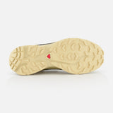 The image displays the beige, textured rubber outsole of the SALOMON XT-6 GTX Sneaker. It features deep treads, a small red triangular logo at the center, and is photographed against a white background.