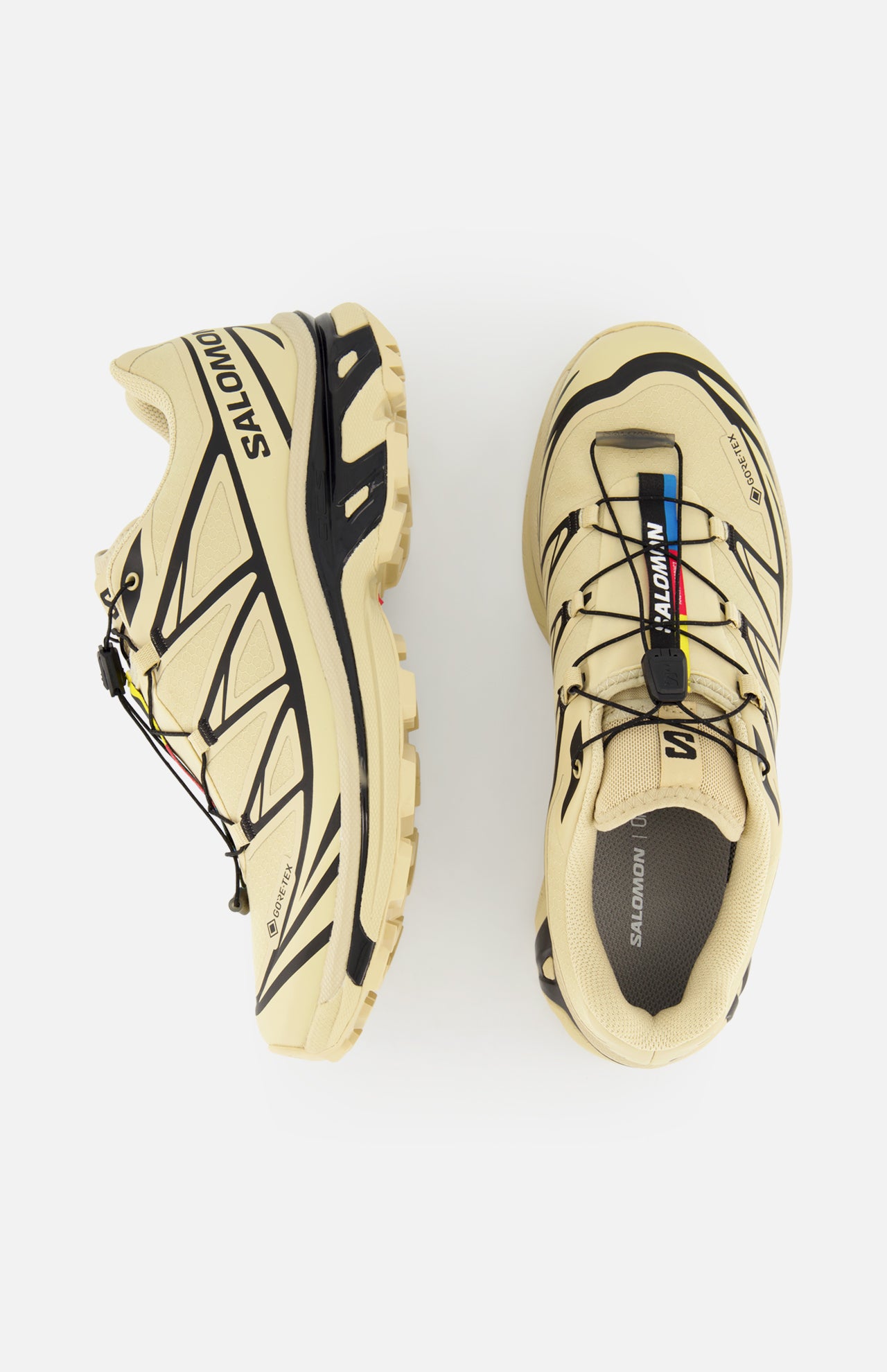 The SALOMON XT-6 GTX Sneaker in beige features black accents, rainbow lace loop details, a quick lace system, and SALOMON branding on the side and tongue. Shown from side and top view on a white background.