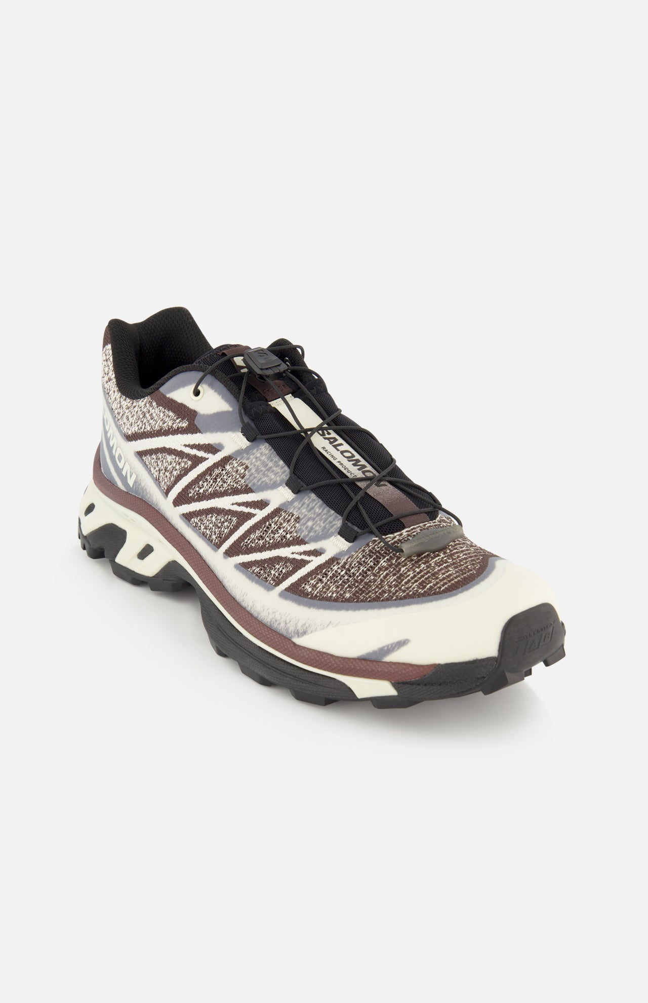 The SALOMON XT-6 Shadow Sneaker is a single ultra-distance race shoe showcasing a white, black, and brown pattern, finished with black laces and a rugged black sole for exceptional durability and cushioning, displayed on a white background.
