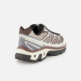 A single SALOMON XT-6 Shadow Sneaker is shown from the back left side, highlighting its mesh upper, white zigzag detailing, a thick white and brown sole engineered for superior cushioning and durability, and black tread, all set against a plain white background.