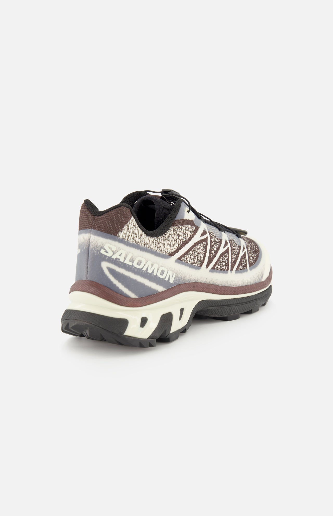 A single SALOMON XT-6 Shadow Sneaker is shown from the back left side, highlighting its mesh upper, white zigzag detailing, a thick white and brown sole engineered for superior cushioning and durability, and black tread, all set against a plain white background.