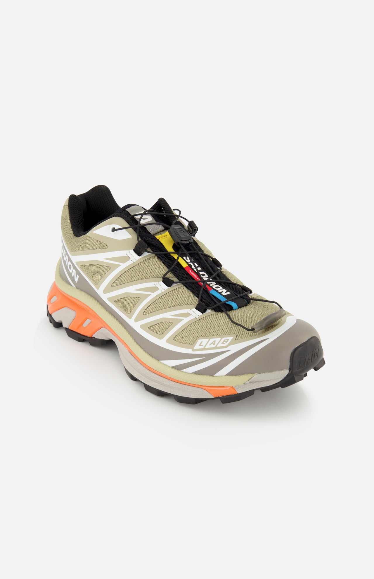 Salomon XT-6 sneaker in olive green with a quick-lace system, white geometric overlays, and a cushioned orange midsole.
