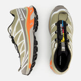 Top-down view of olive green Salomon XT-6 sneakers with orange midsole accents, cushioning, and a quick-lace system.
