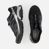 The SALOMON XT-Pathway GTX Sneaker is shown in black from side and top views on a white background, featuring rugged soles, lace-up closures, and a quick lace system ideal for ultra-distance races.