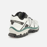 The SALOMON XT-Quest Sneaker in a white and black colorway is displayed from a rear side angle against a plain white background, showcasing its hybrid performance design for optimal stability and grip—making it perfect for both challenging trails and everyday urban wear.