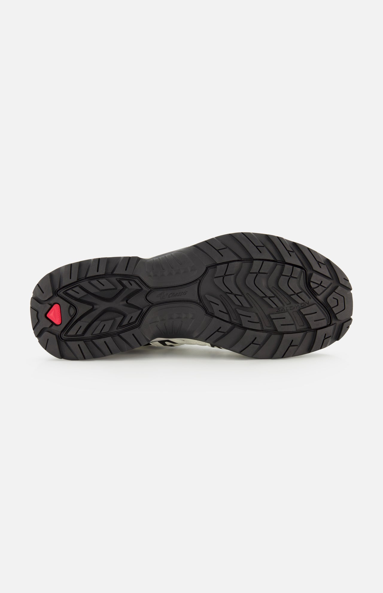 The image displays the black rubber outsole of the SALOMON XT-Quest Sneaker, showcasing its textured tread pattern engineered for stability and grip, along with a subtle red accent near the heel—a feature that makes this hybrid performance sneaker well-suited for urban wearability.