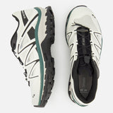 A pair of SALOMON XT-Quest Sneakers in a white and black colorway, one shown in a side profile and the other from an overhead view against a white background. Engineered for stability and grip, these hybrid trail running shoes deliver versatile performance suitable for both urban environments and outdoor adventures.