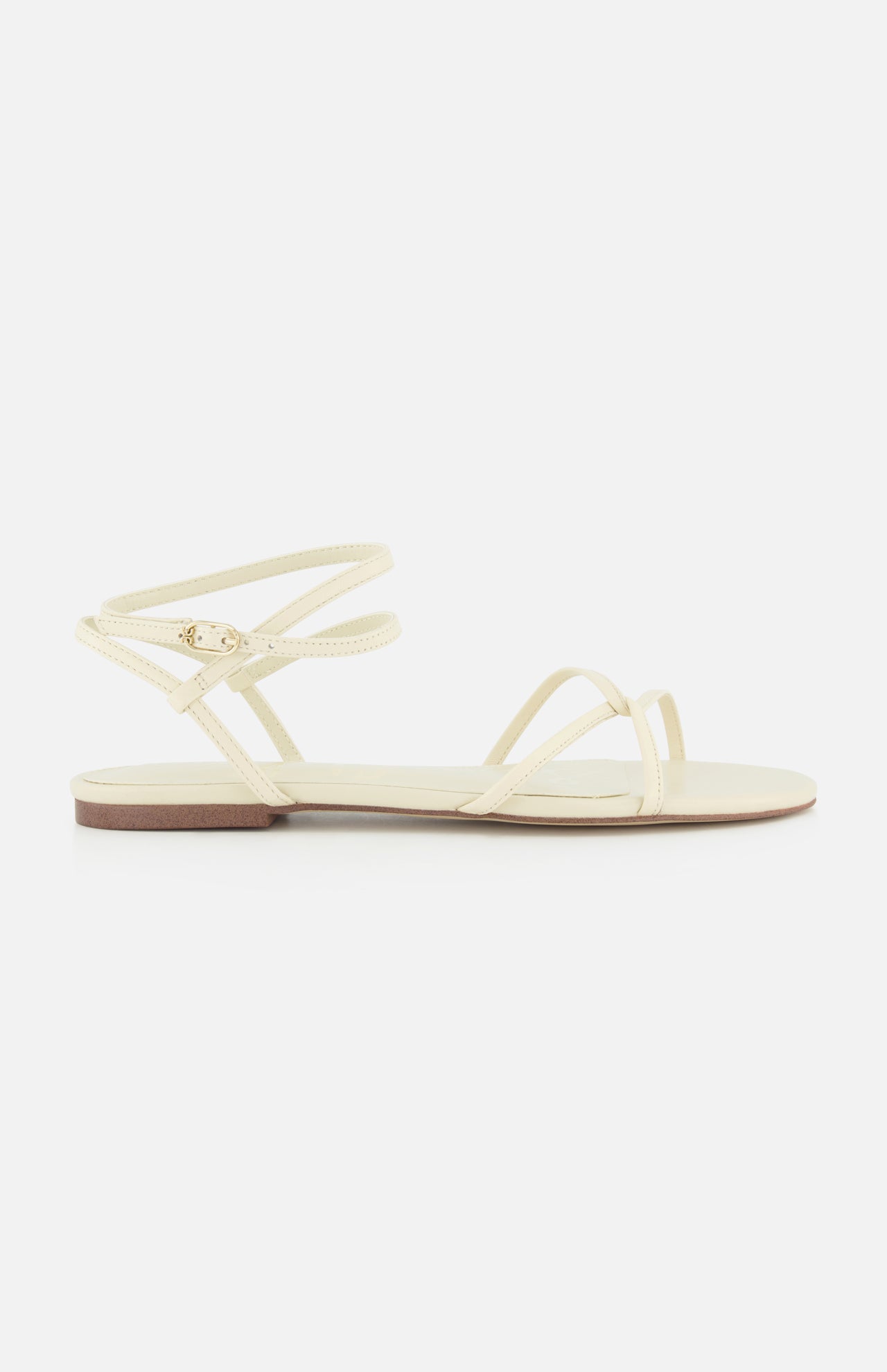The Ellina Strappy Flat Sandal by SAM EDELMAN is a minimalist off-white sandal with thin crisscross straps, a small ankle buckle, and a cushioned footbed for all-day comfort.