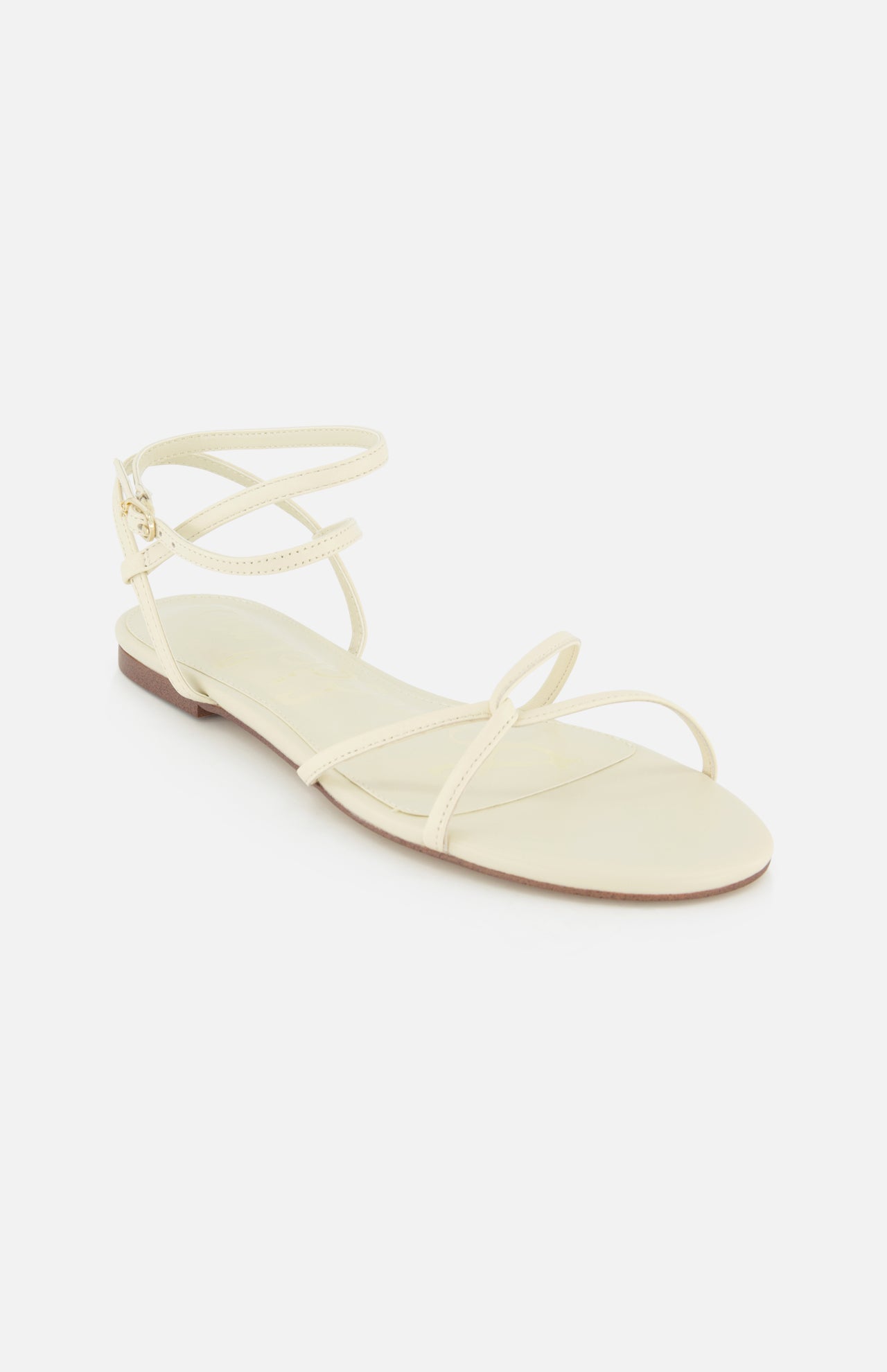 The Ellina Strappy Flat Sandal by SAM EDELMAN, shown on a white background, features an off-white color, thin straps, open toe, cushioned footbed, and an ankle buckle closure.