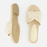 The SAM EDELMAN Miya Woven Sandal features beige raffia with thick braided straps and flat soles; shown on a white background with one sandal in top view and the other displaying the sole.
