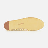 The image shows the bottom of the Shira Woven Leather Flat by SAM EDELMAN in beige off-white, with a square toe, small brown heel cap, "Sam Edelman" in cursive at the center, and a smooth sole edged with texture.