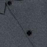 Close-up of a grey wool shirt with two black buttons and a pointed collar, with a glimpse of blue inner lining at the top left corner—an ideal match for the SARTORIO Double Faced Overcoat, expertly crafted in Italy.