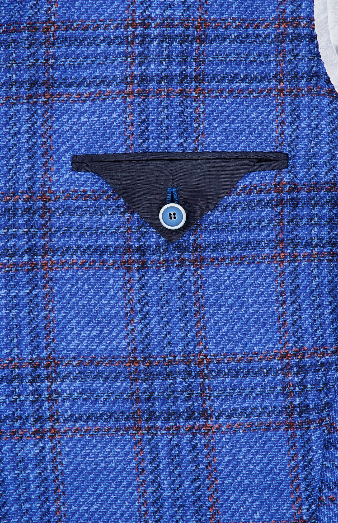 SARTORIO Wool Blend Plaid Sportcoat features blue and red plaid fabric, reminiscent of a classic blue plaid sportcoat, with a small dark blue triangular pocket flap secured by a light blue four-hole button near the center of the image.