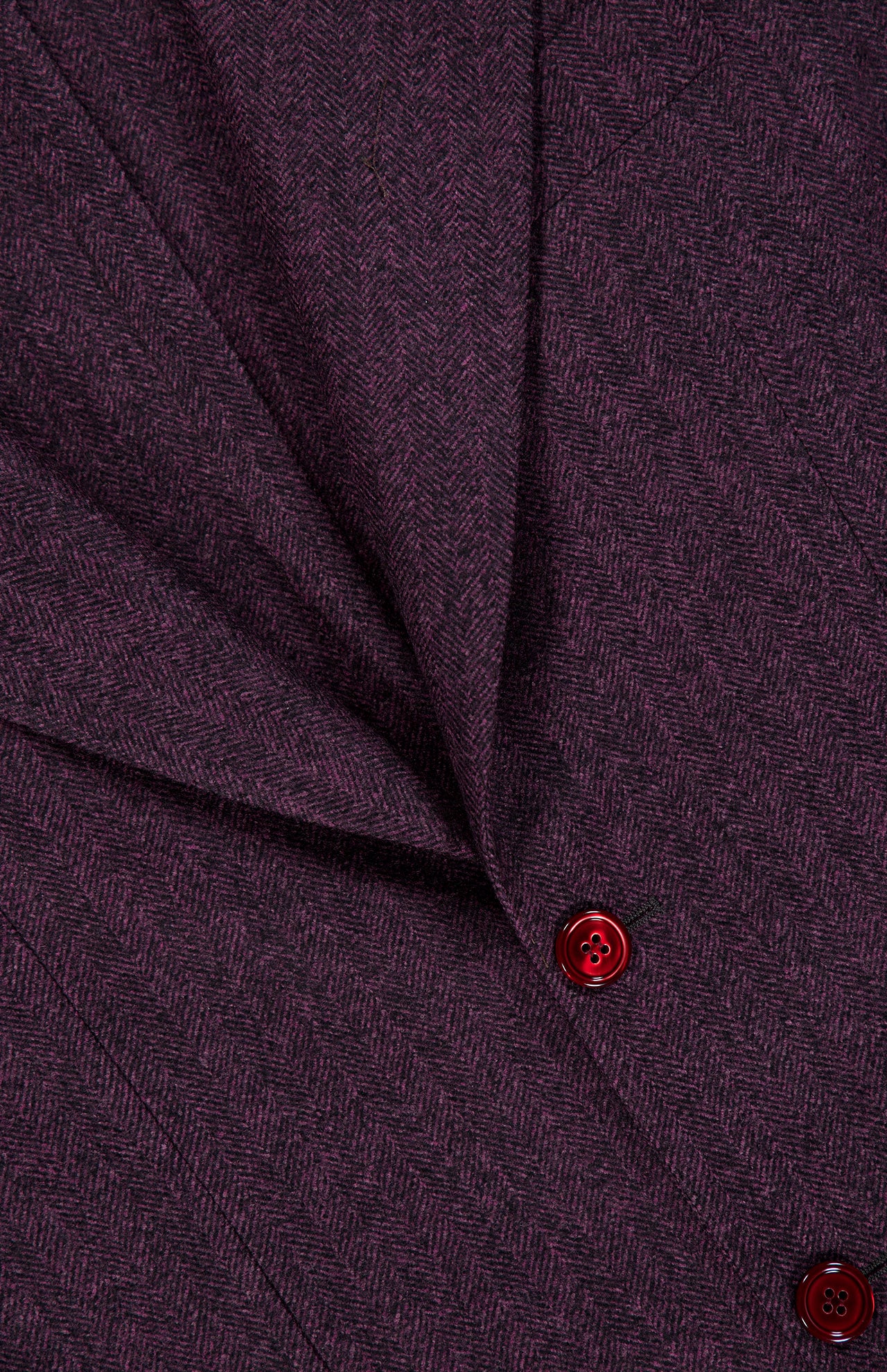 Close-up of the SARTORIO Wool Herringbone Sportcoat in a purple herringbone pattern, showcasing a stitched seam and two red buttons—an Italian-made tailored piece.