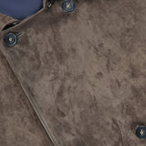 Close-up of the SAVAS Condor Calf Suede Shearling Collar Peacoat in brown, highlighting its soft suede texture, double-breasted front with dark buttons, and a glimpse of the blue inner lining—showcasing refined detailing inspired by classic leather peacoats.