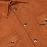 Close-up of the SAVAS Lowry Lamb Suede Overshirt, crafted in brown lamb suede with metal snap buttons, two front flap pockets, and detailed visible stitching. This premium overshirt is expertly made in Italy.