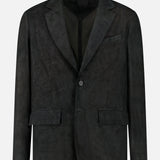 The Owens Lamb Leather Blazer by SAVAS, shown against a plain white background, features notched lapels, two buttons, flap pockets, and a breast pocket. Handcrafted in an artisanal style from black lamb leather.