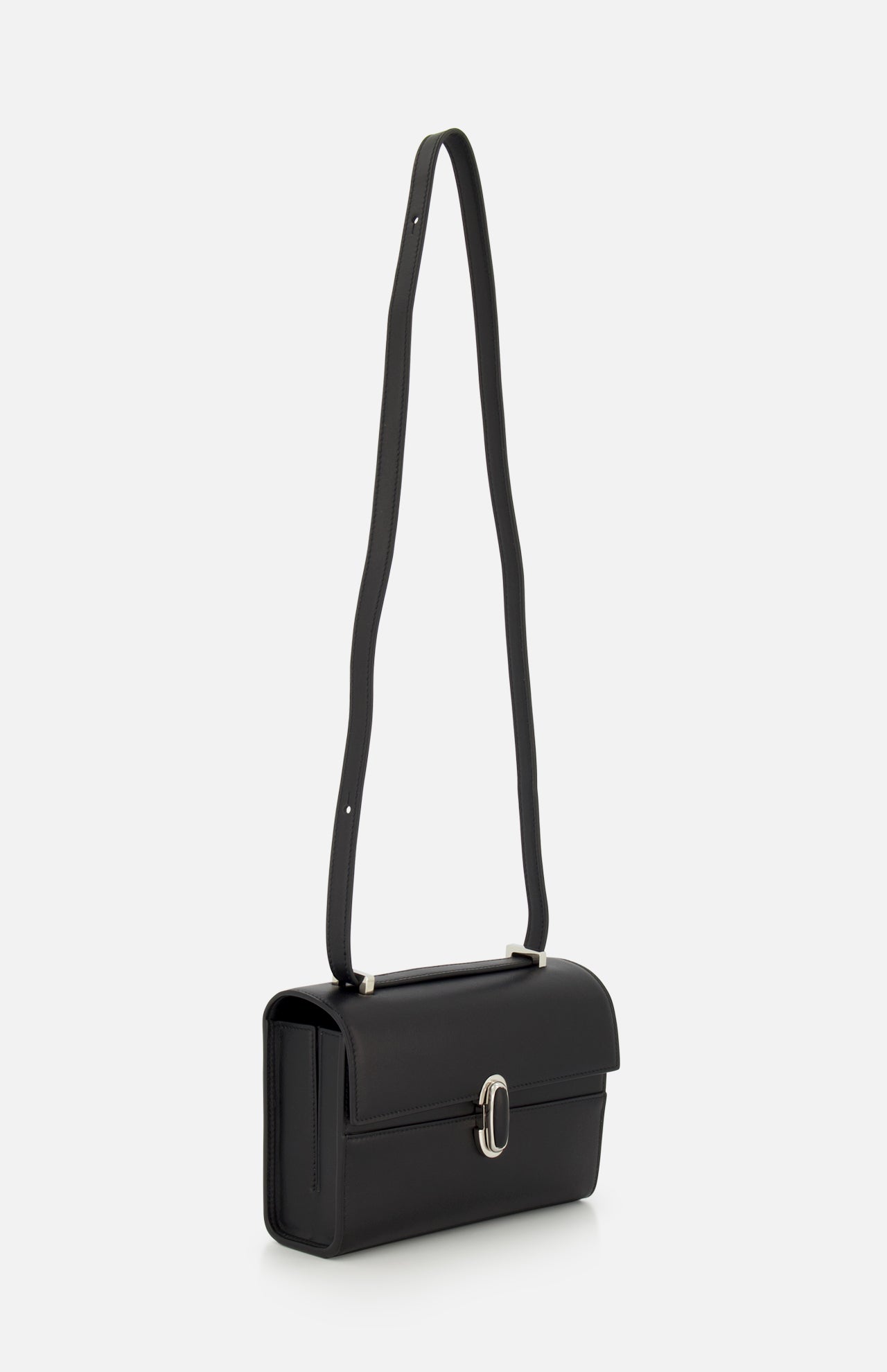 The Symmetry 19 Bag by Savette is a sleek black leather crossbody featuring a long, wide strap and a sophisticated silver oval turnlock closure on the front flap, displayed against a plain white background.