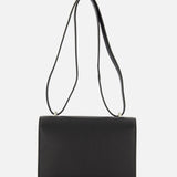 The Symmetry 19 Bag by Savette is a rectangular black leather crossbody featuring a long, slender double strap and an elegant turnlock closure, shown against a plain white background.