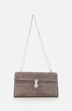 The Symmetry Chain Pouchette Bag by Savette features taupe suede, a silver chain strap, and an elegant turnlock closure on the front, displayed against a white background.