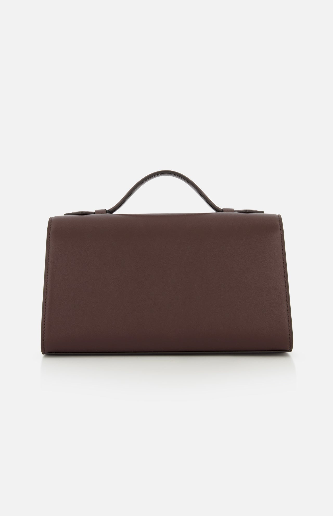 The Symmetry Pouchette Bag by Savette, a rectangular brown leather handbag with a top handle that embodies quiet luxury, is displayed against a plain white background.