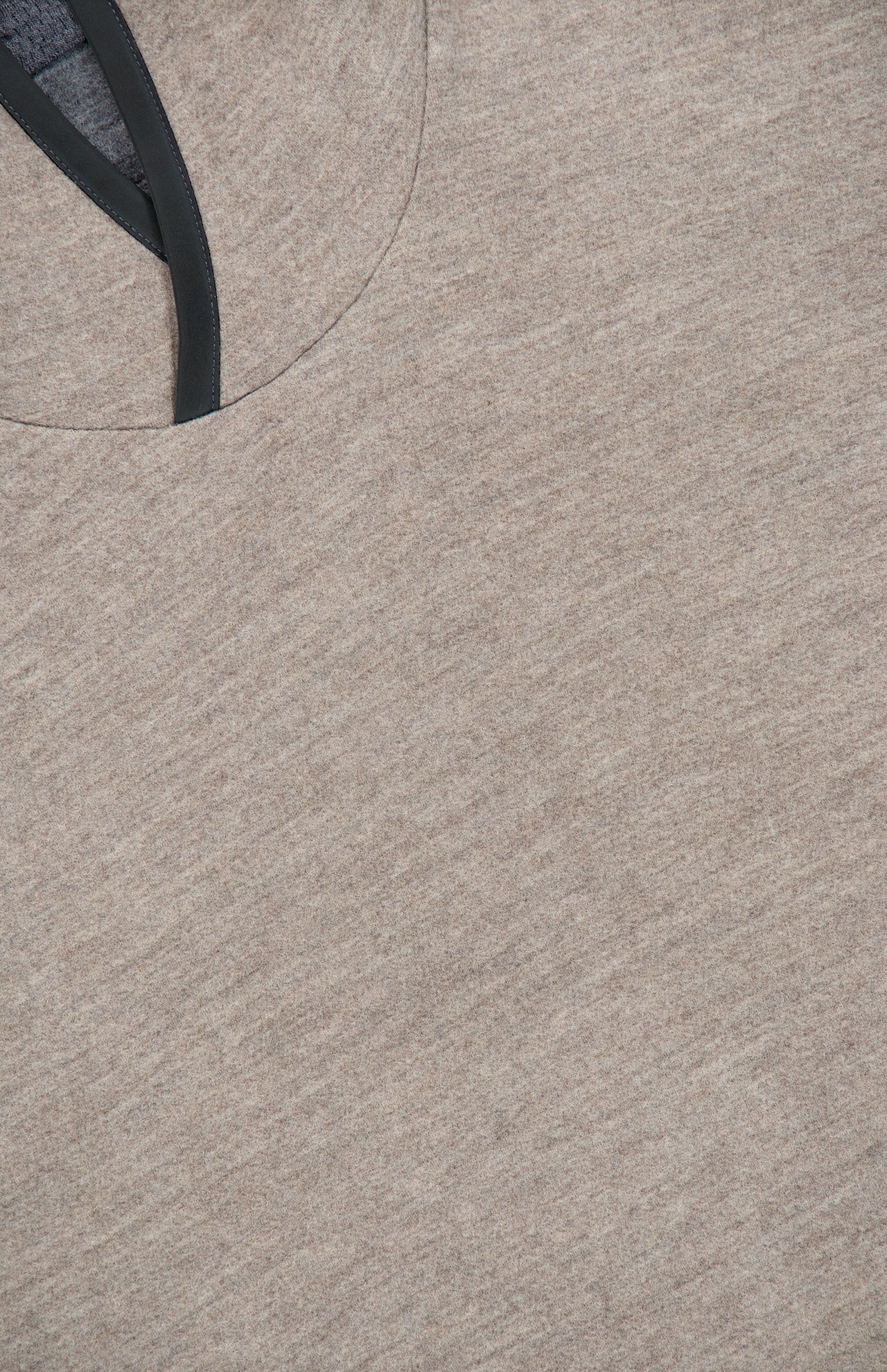 Close-up of the SEASE Drone Hooded Pullover, showcasing its light brown heathered fabric and black-trimmed neckline, viewed from above.