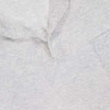Close-up of the SEASE Linen Pocket Polo Shirt in light grey linen-blend fabric, with a subtle Johnny collar, short placket, small chest pocket, and a visible dark blue SEASE tag inside the neckline.