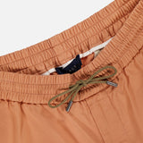 Close-up of SEASE’s Summer Mindset Drawstring Trouser Pant in light brown pastel, featuring an elastic waistband and green drawstring with metal tips, shown against a white background.