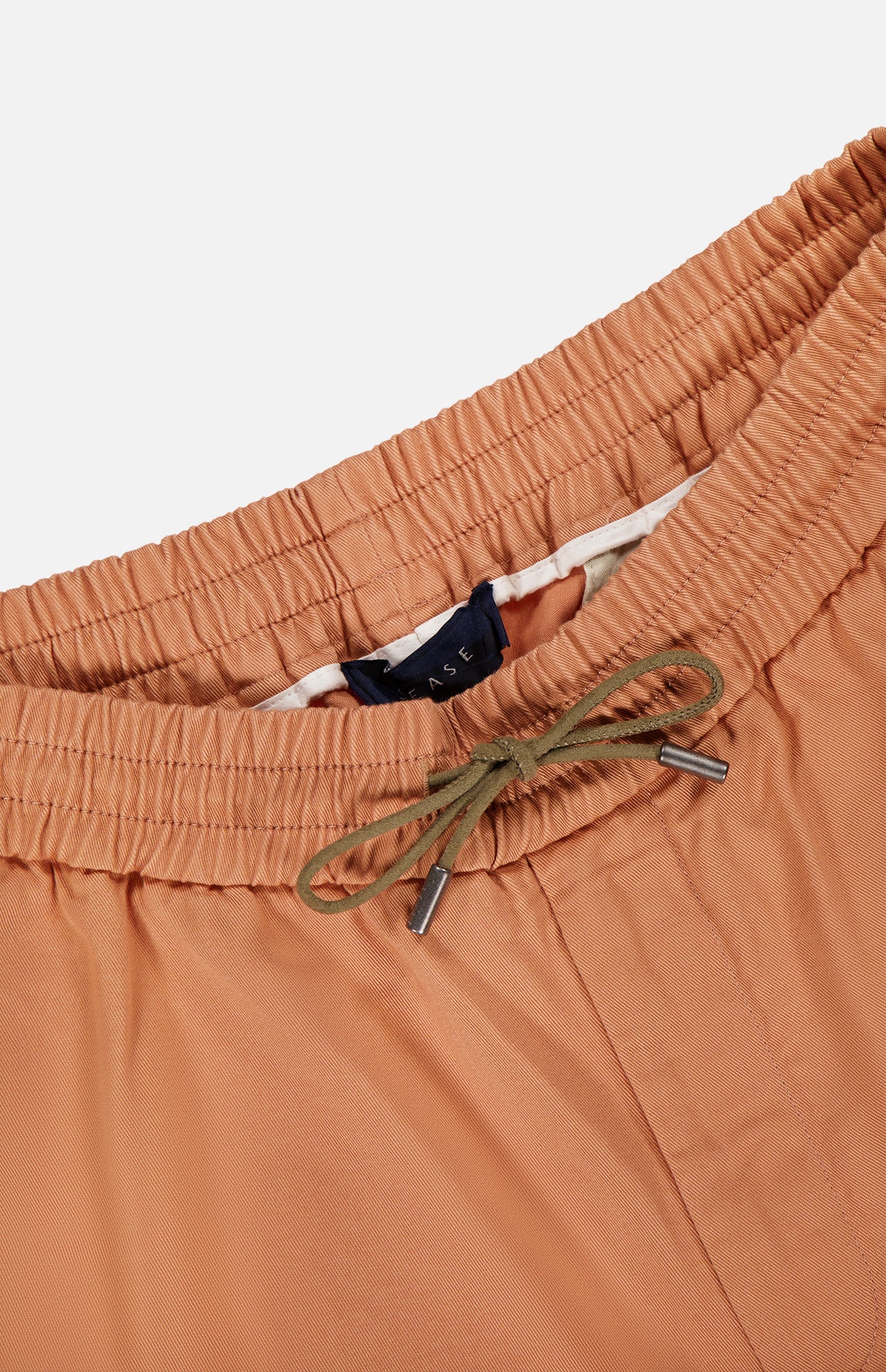 Close-up of SEASE’s Summer Mindset Drawstring Trouser Pant in light brown pastel, featuring an elastic waistband and green drawstring with metal tips, shown against a white background.