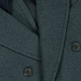 Close-up of the DORIANI Double Breasted 180′s Jersey Coat in gray, made in Italy from fine virgin wool, featuring wide lapels and black buttons, layered over a dark garment.