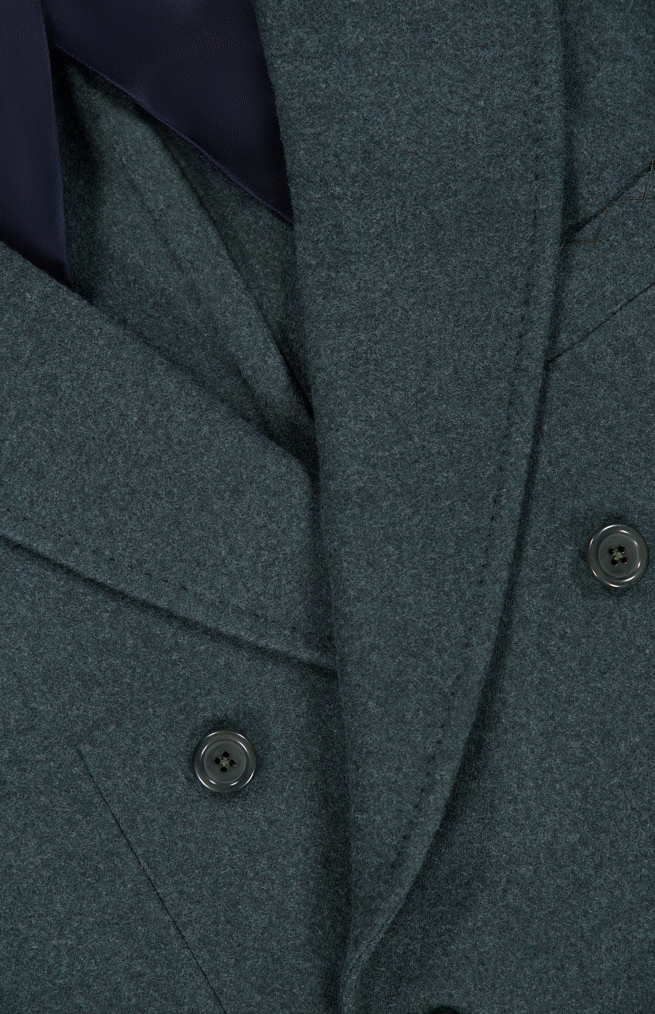 Close-up of the DORIANI Double Breasted 180′s Jersey Coat in gray, made in Italy from fine virgin wool, featuring wide lapels and black buttons, layered over a dark garment.