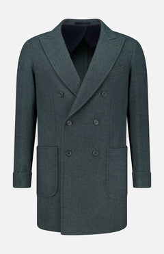 The Double Breasted 180′s Jersey Coat by DORIANI is a dark grey, double-breasted design crafted from luxurious virgin wool and features wide lapels, six buttons, two large front pockets, and folded cuffs. Made in Italy, it is displayed on a plain white background.