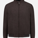 The DORIANI Fur 180′s Jersey Bomber Jacket, a chocolate brown wool piece handcrafted in Italy, features a plush shearling collar lining, ribbed cuffs and hem, and a sleek silver zipper. Presented flat against a white background.