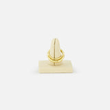 The SPINELLI KILCOLLIN Agon Vulcan Ring, crafted in yellow gold, is displayed on a beige velvet ring stand against a white background, highlighting its elegant, fluid design.