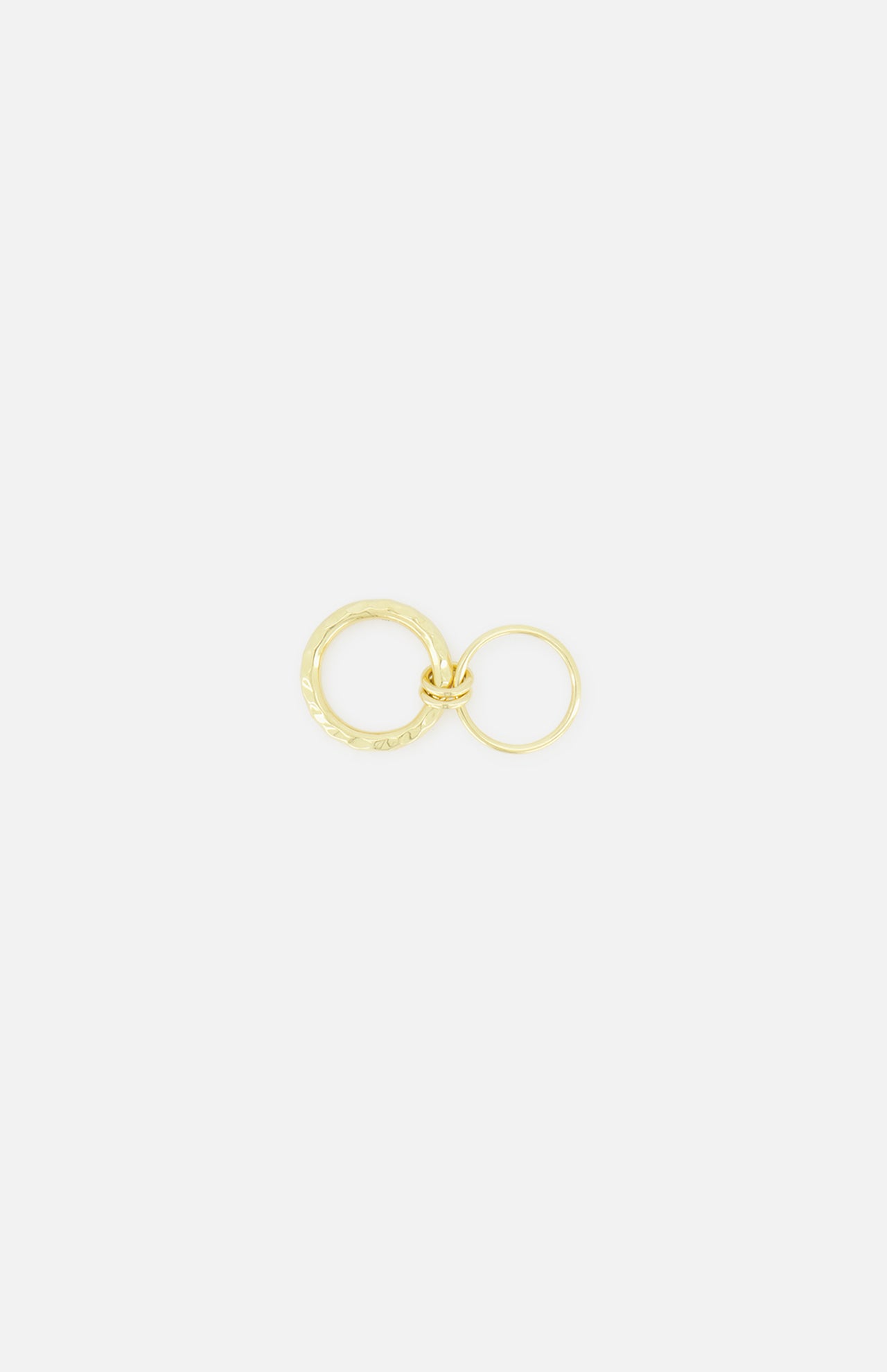 Two yellow gold Agon Vulcan Rings by SPINELLI KILCOLLIN, each in a different size with fluid designs, are interlinked and set against a plain white background.