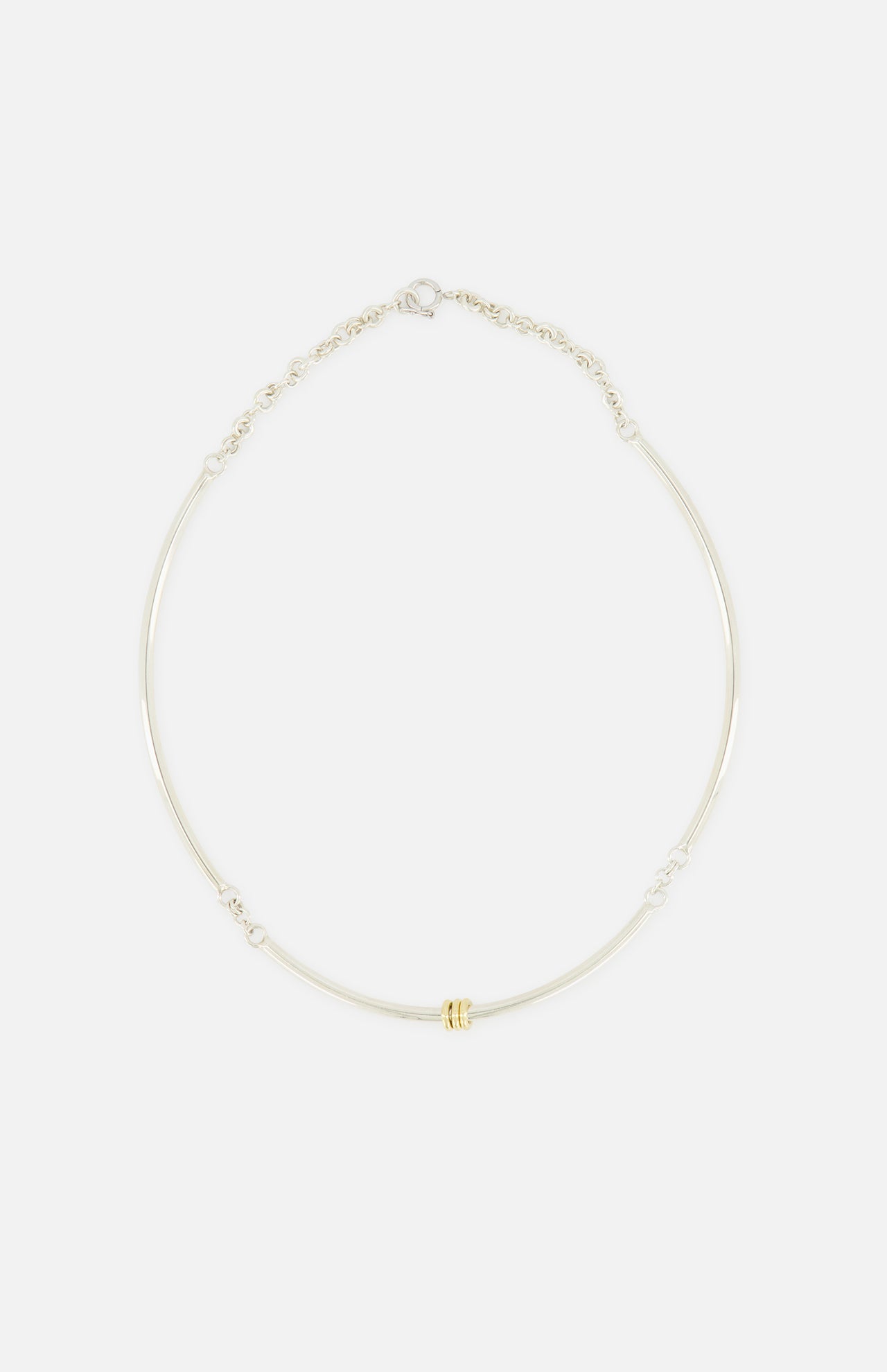 The Hello Tria Silver Necklace by SPINELLI KILCOLLIN features a simple sterling silver chain accented with three gold rings, shown against a plain white background.