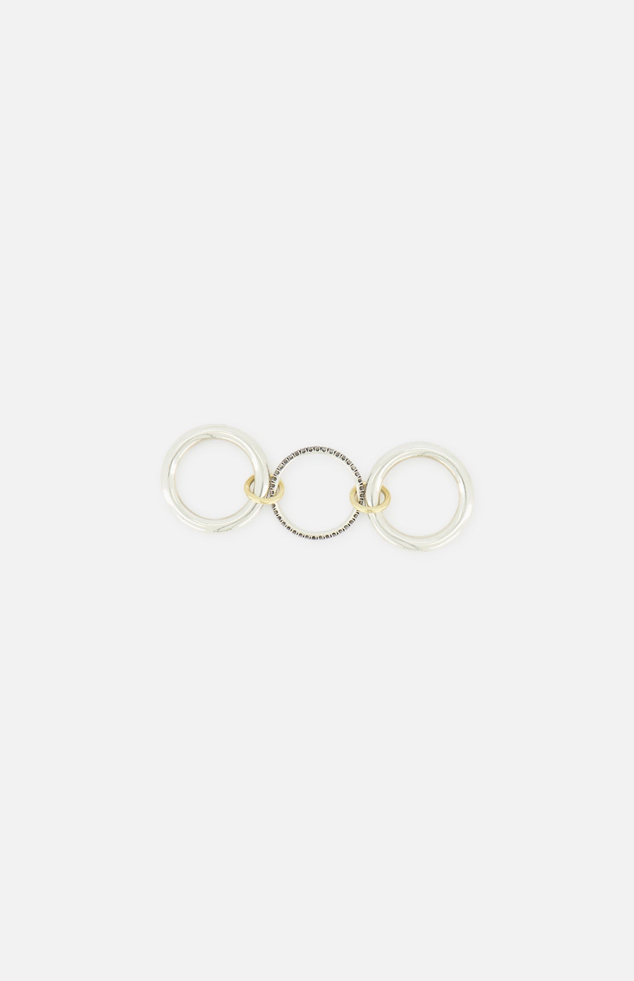 The Libra Gris Diamond Ring by SPINELLI KILCOLLIN features three interlocking rings—two in sterling silver and one in gold—linked together and displayed flat on a white background.