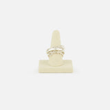 The Microdame SK Ring by SPINELLI KILCOLLIN features an interlocking chain design inspired by modular jewelry, shown upright on a beige ring stand against a plain white background.
